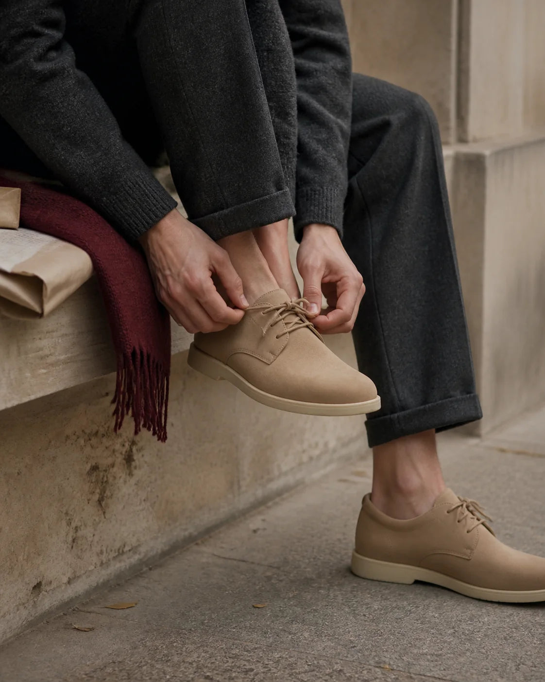 Person bindet einen neutralen Schuh als redaktionelles Motiv zur Passform